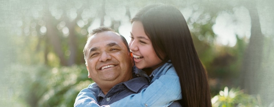 Young girl on her father's back outside